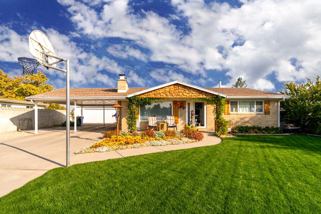 Midcentury-style prefab home with covered carport and landscaped yard.