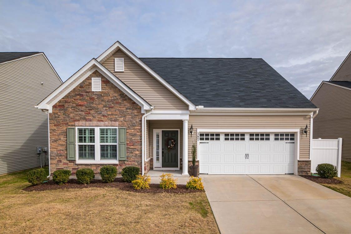 Ranch-style modular home with stone front, garage, and manicured landscaping.